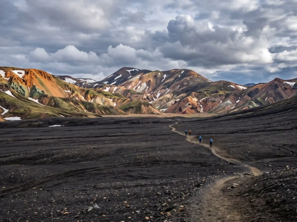 Vibrant rhyolite mountain peaks displaying natural minerals under dramatic cloudy skies in Iceland