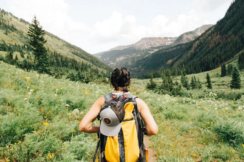 Flat lay of essential camping gear with mountain backpack stove cookware and topography map