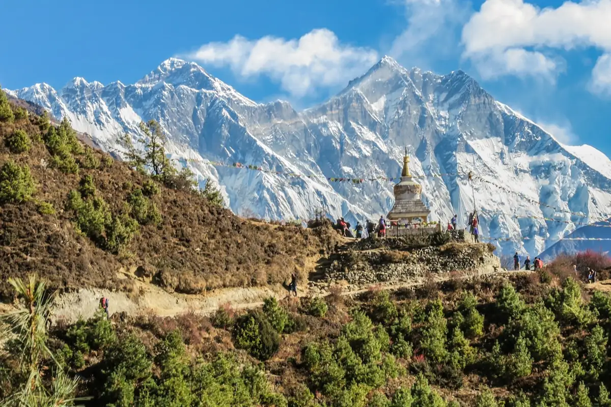 Backpacker wearing technical outdoor layering apparel while trekking high alpine valley in Nepal