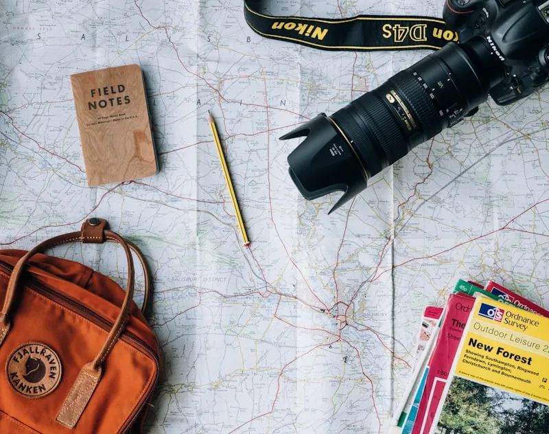 Paper travel journal and detailed city street map sitting beside warm coffee cup