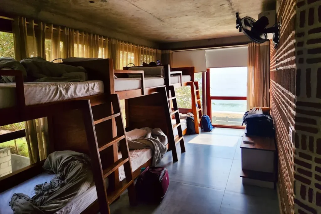 Modern boutique hostel lounge with backpackers and travelers socializing