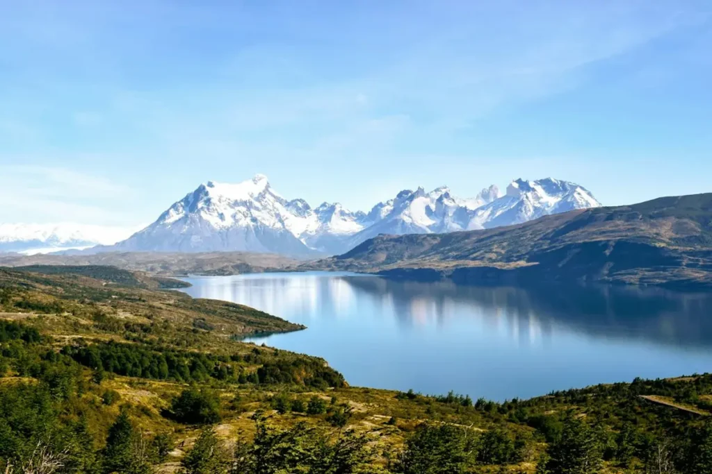 Hikers trekking on a scenic mountain trail in Patagonia with snow-capped peaks