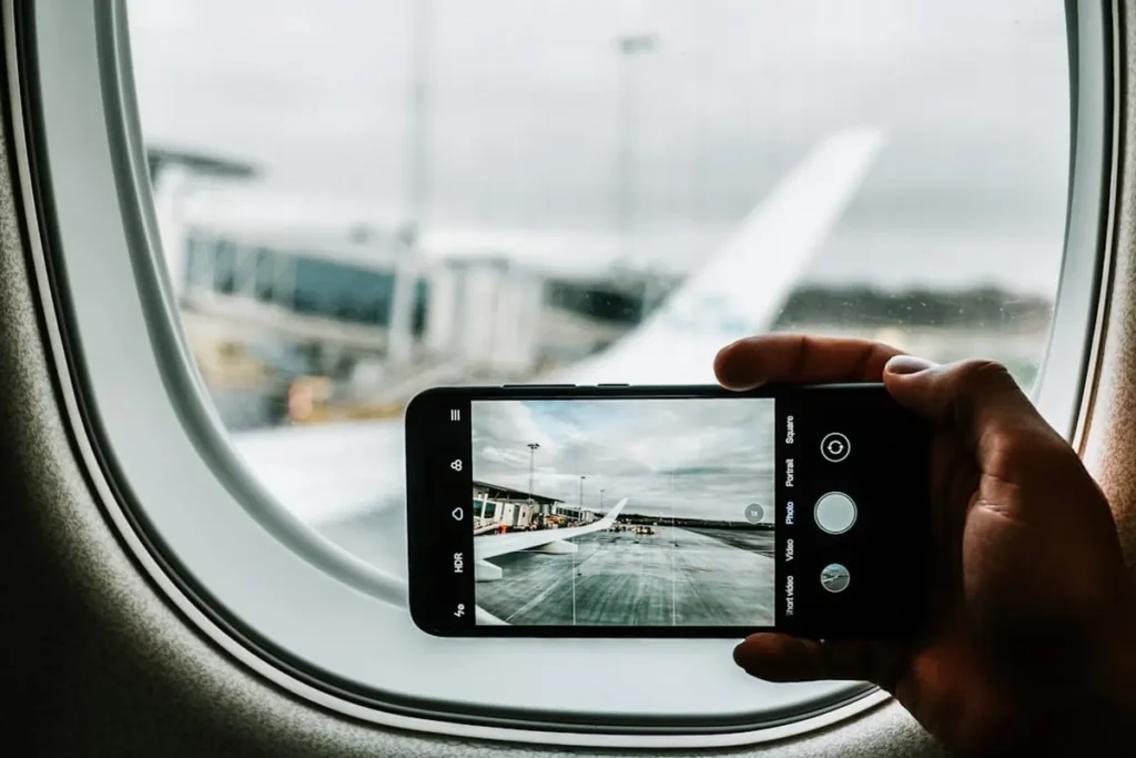 Traveler holding smartphone displaying travel navigation map at modern transit terminal