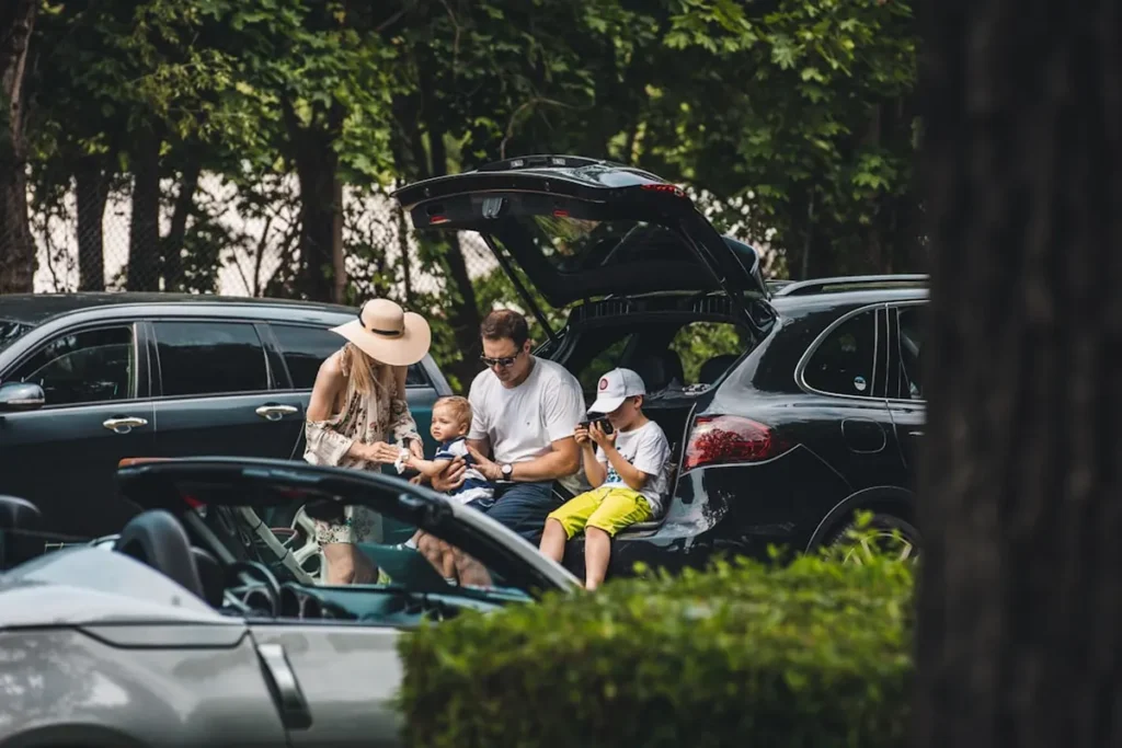 Family packing luggage into car for a summer scenic road trip