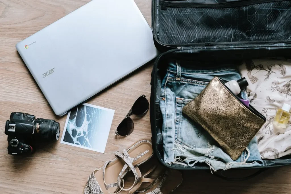 Open suitcase packed with travel essentials, passport, and boarding documents